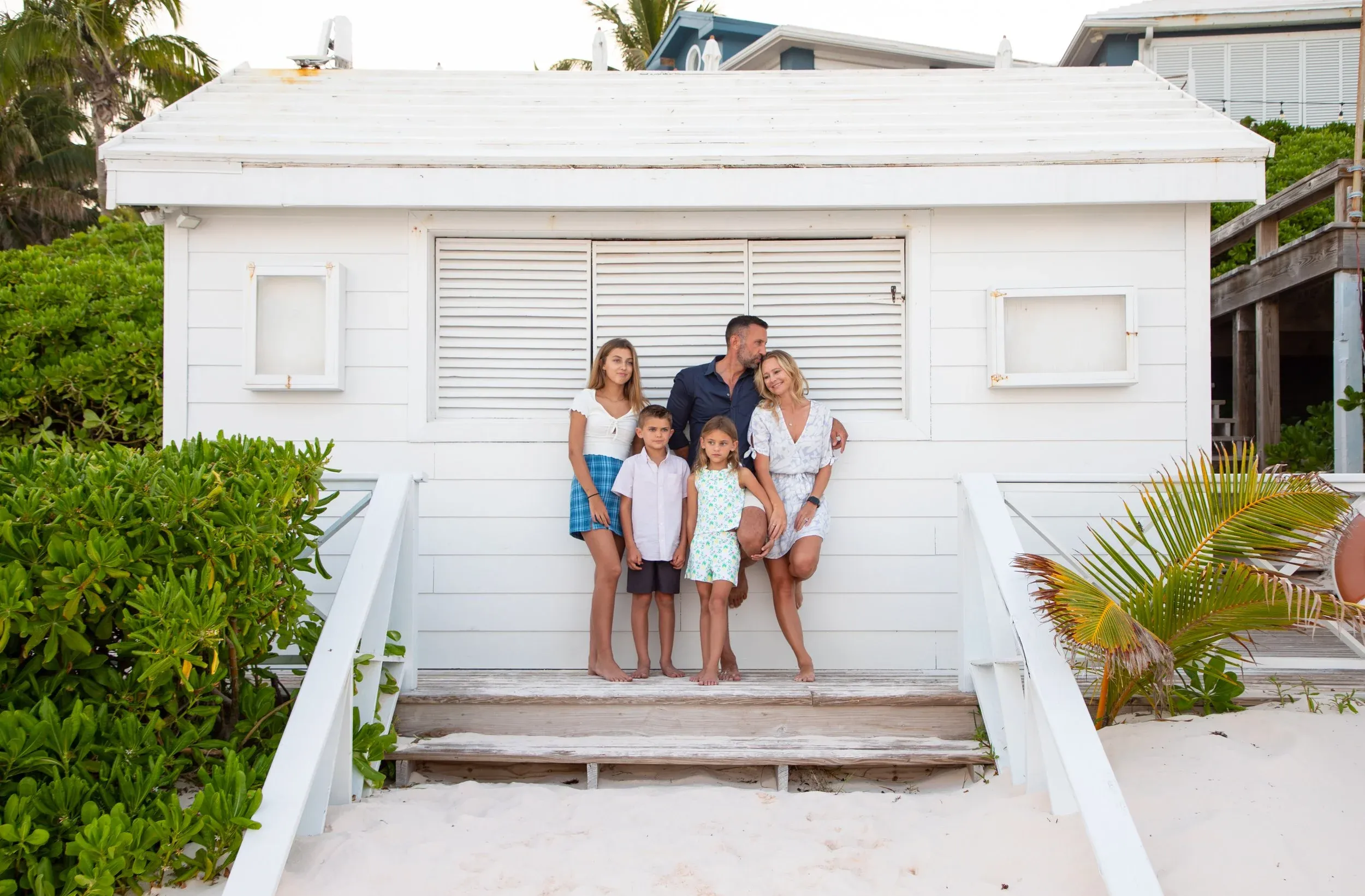 The Lockwood family stands together in front of a white beach building