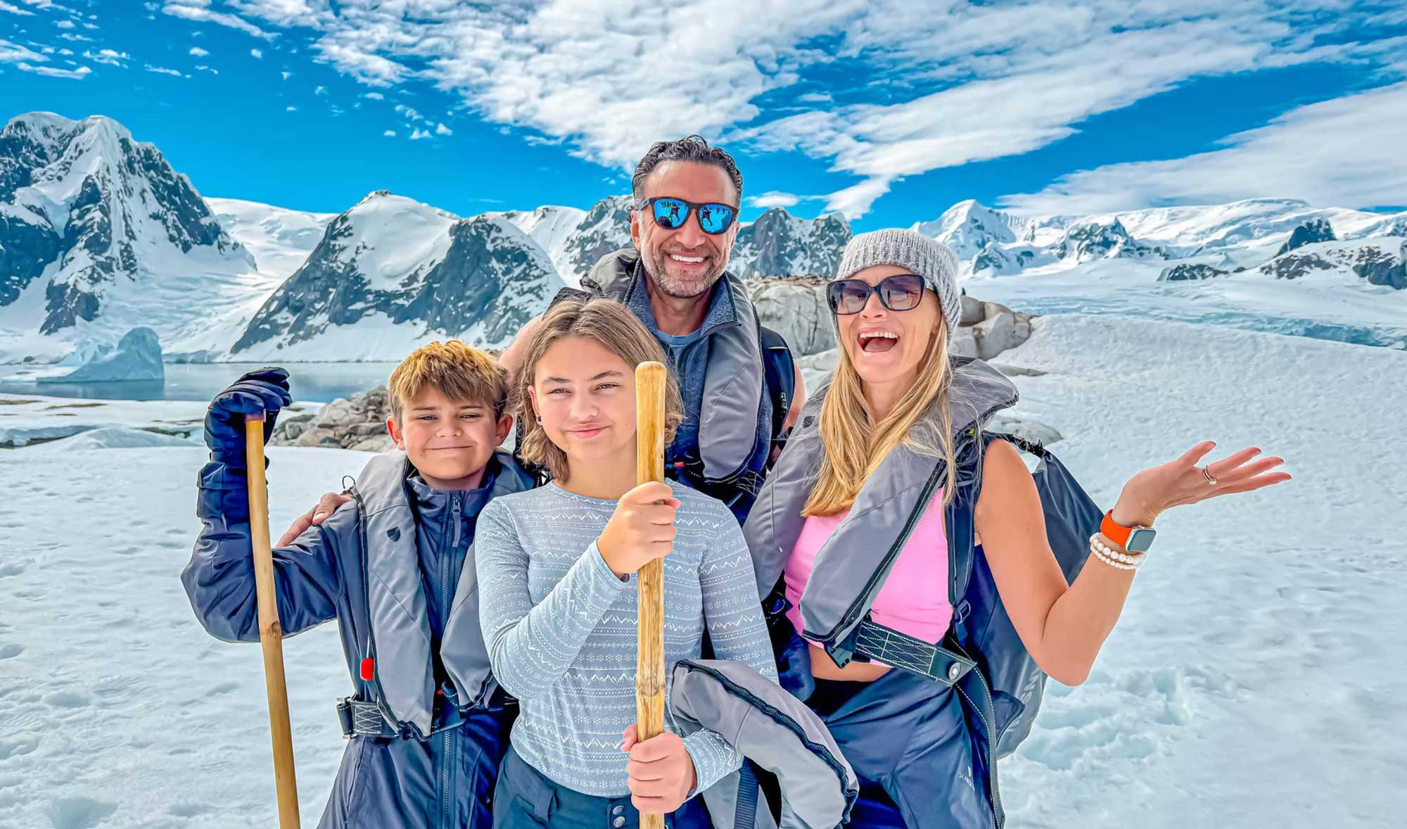 The Lockwood family poses in front of Antarctic mountains