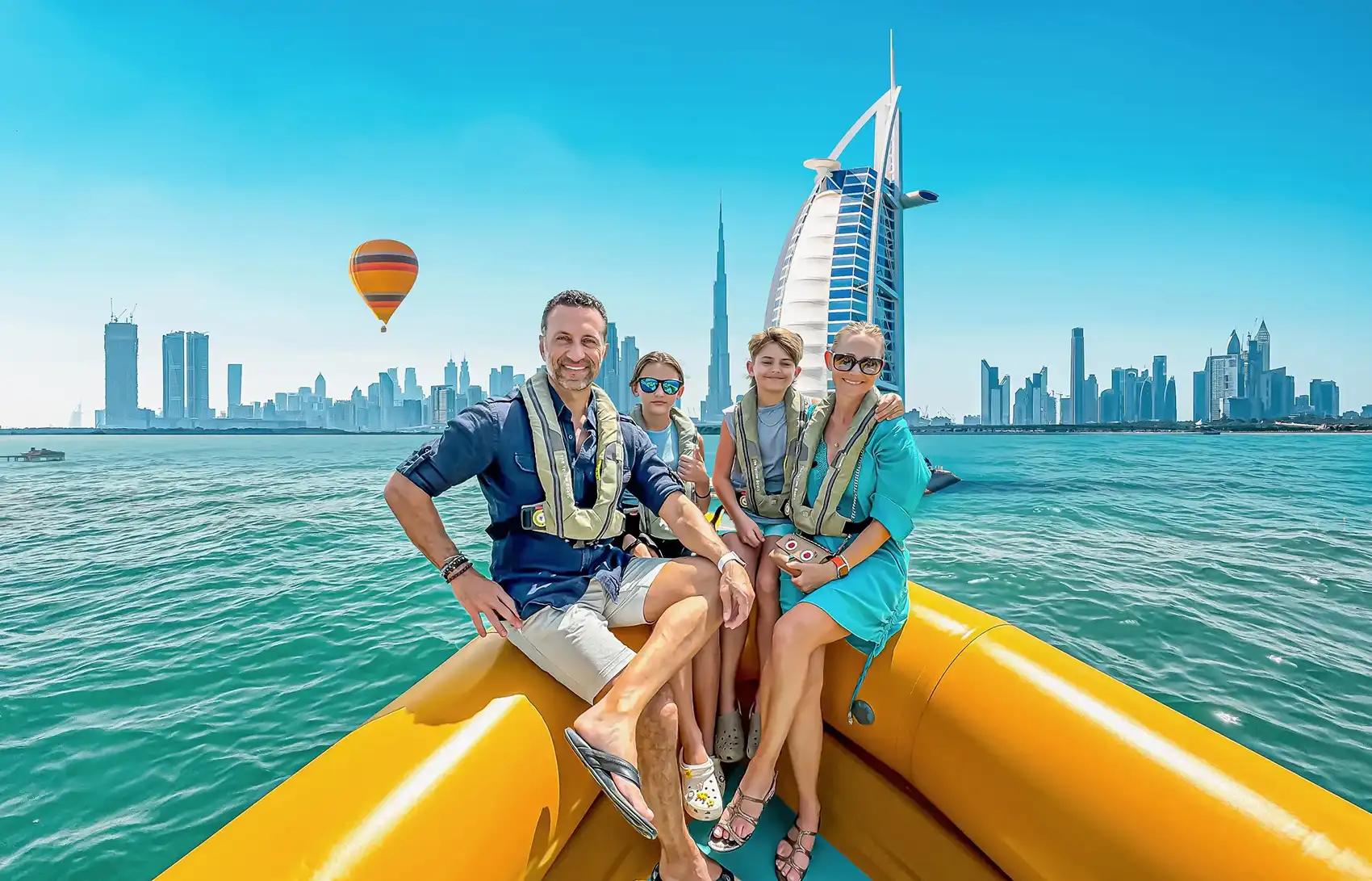 The Lockwood family sits on a small boat with the Dubai skyline in the background