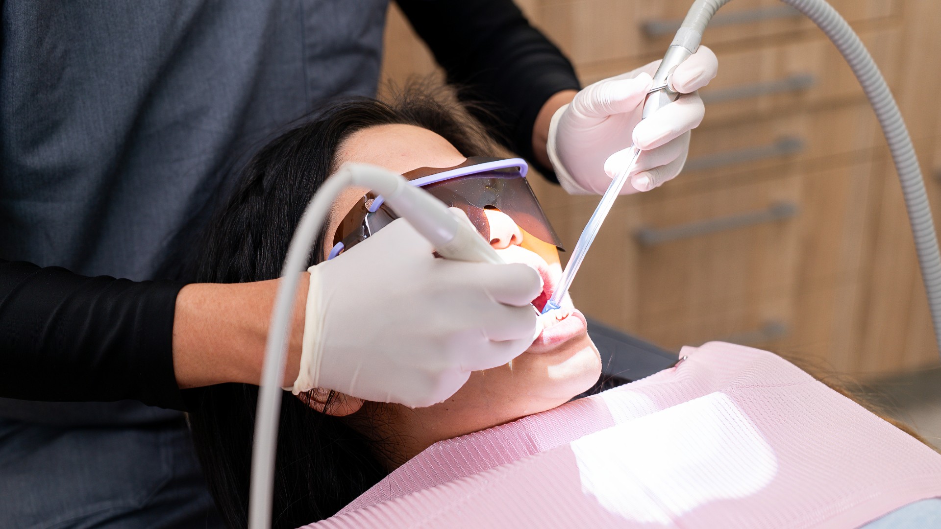 Dentist cleaning a patient's teeth at Lumi Dental