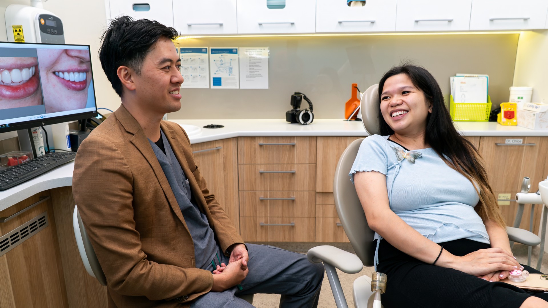 Dr James Tran consulting with a patient at Lumi Dental, explaining treatment options with a smile