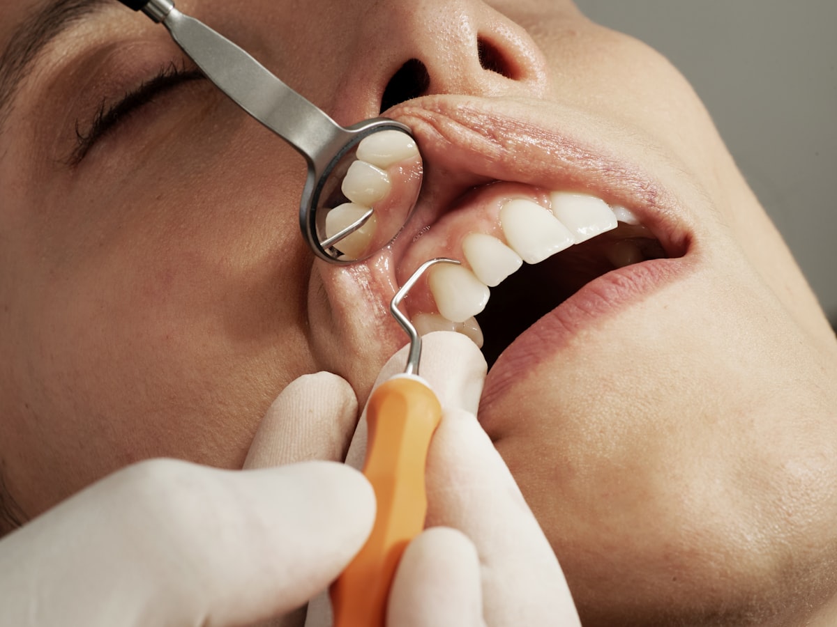 Paediatric dentist checking a child's tooth to decide if a baby tooth extraction is needed