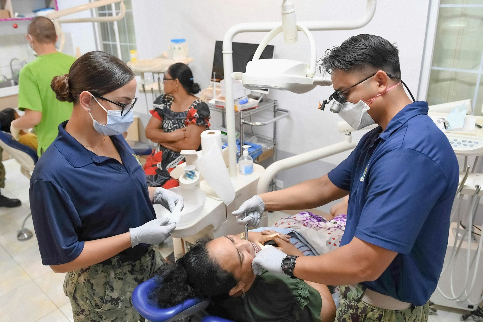Dentists examining a patient's teeth and gums during a check-up