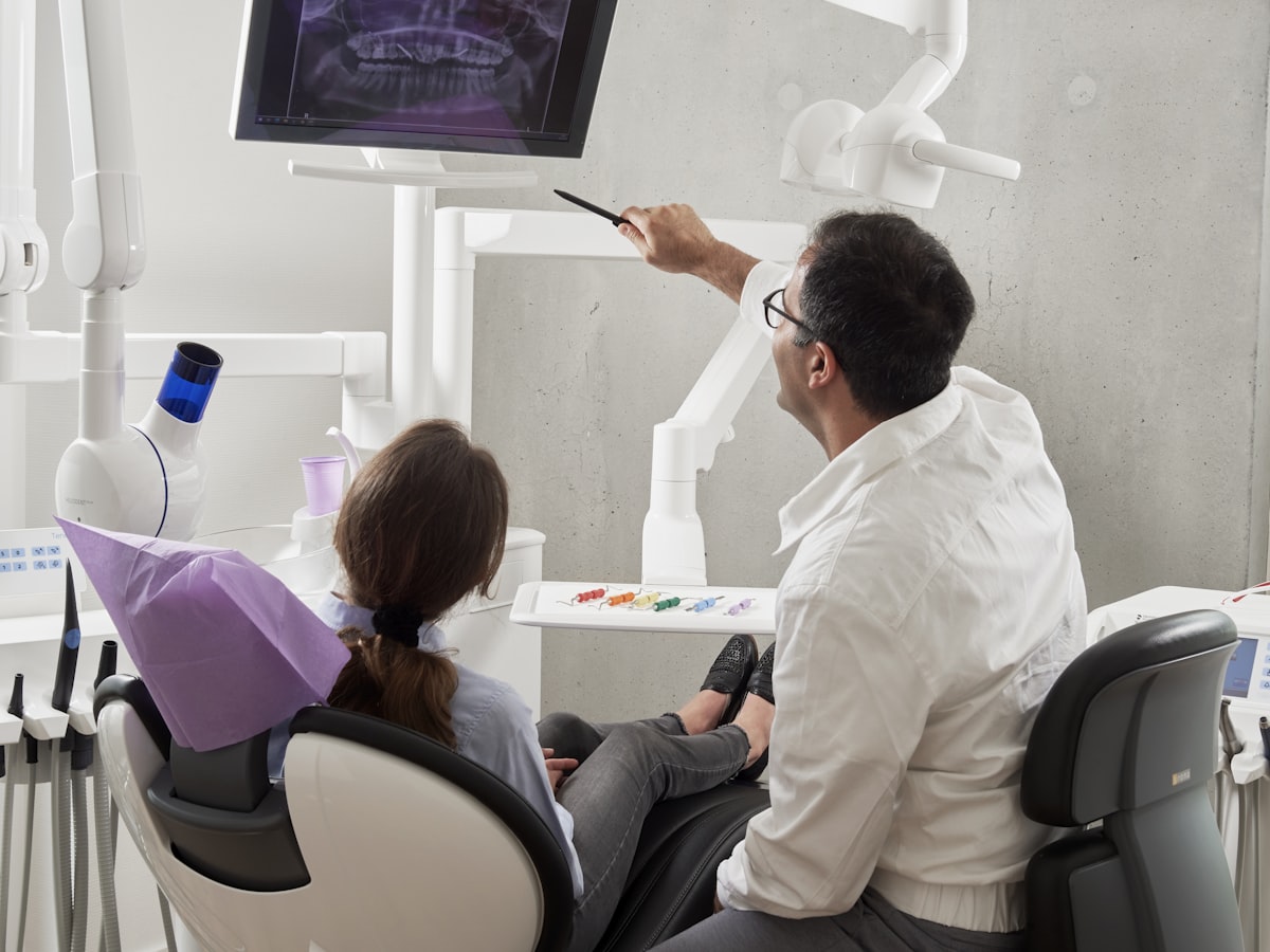 Dentist and patient reviewing an X-ray on a monitor during a consultation