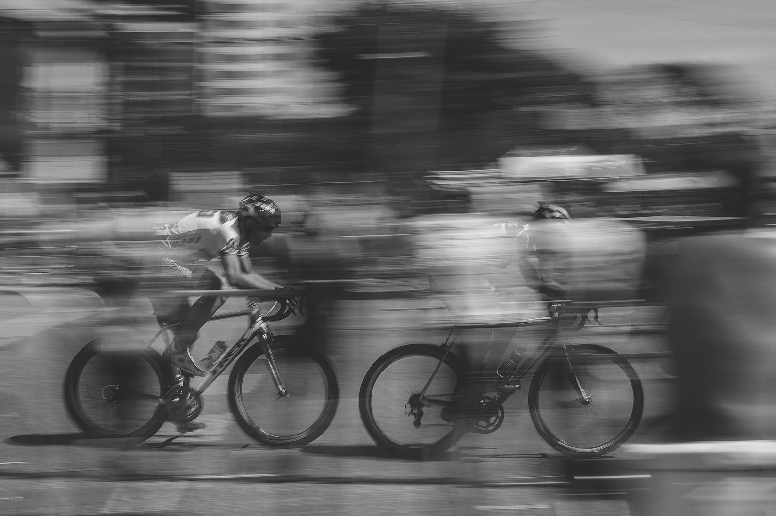 Cyclist climbing a steep hill with visible effort and jaw tension