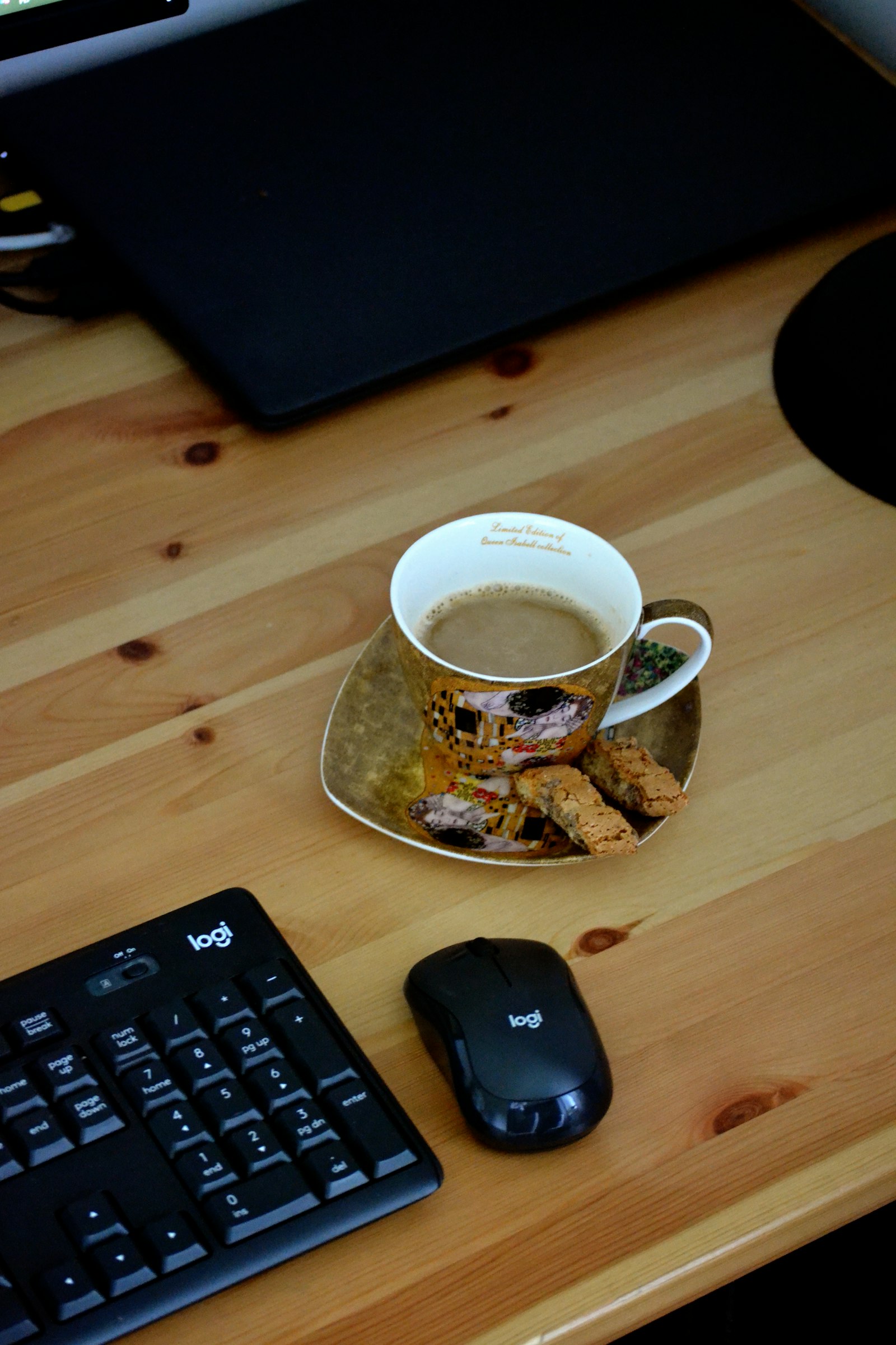 A coffee cup beside a keyboard and mouse on a desk, showing everyday desk workers dental health habits