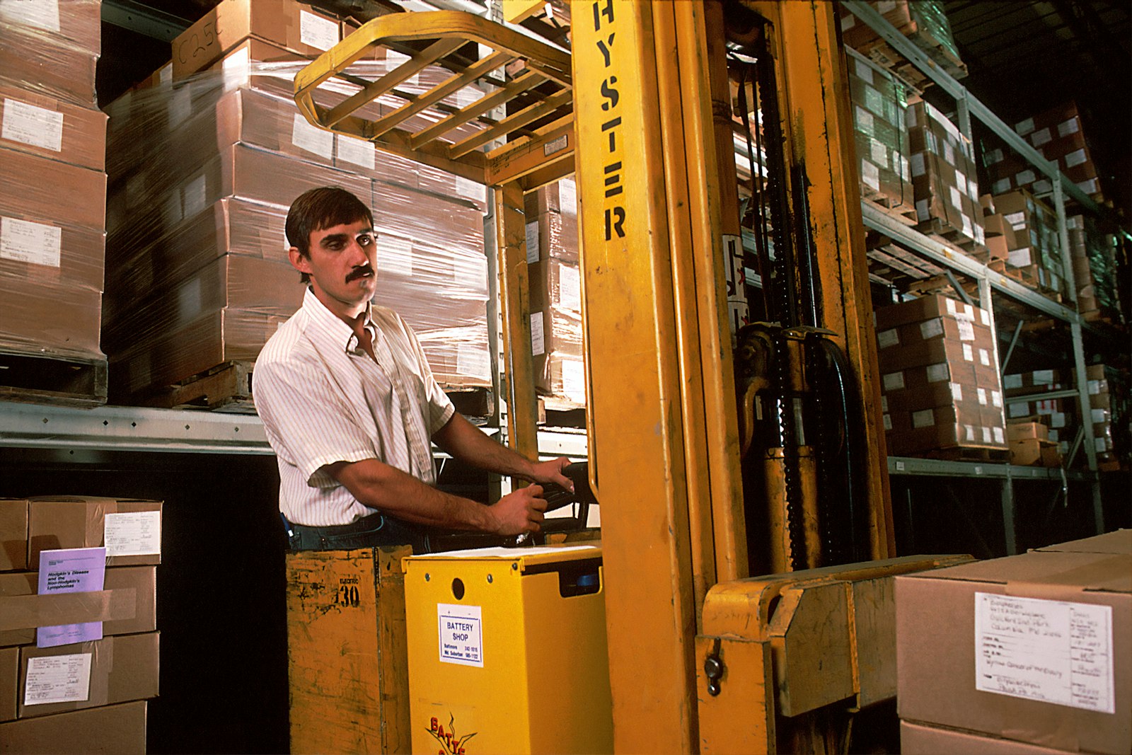 Yellow forklift operating in a warehouse aisle, illustrating why warehouse worker dental injury risk and mouth protection matter