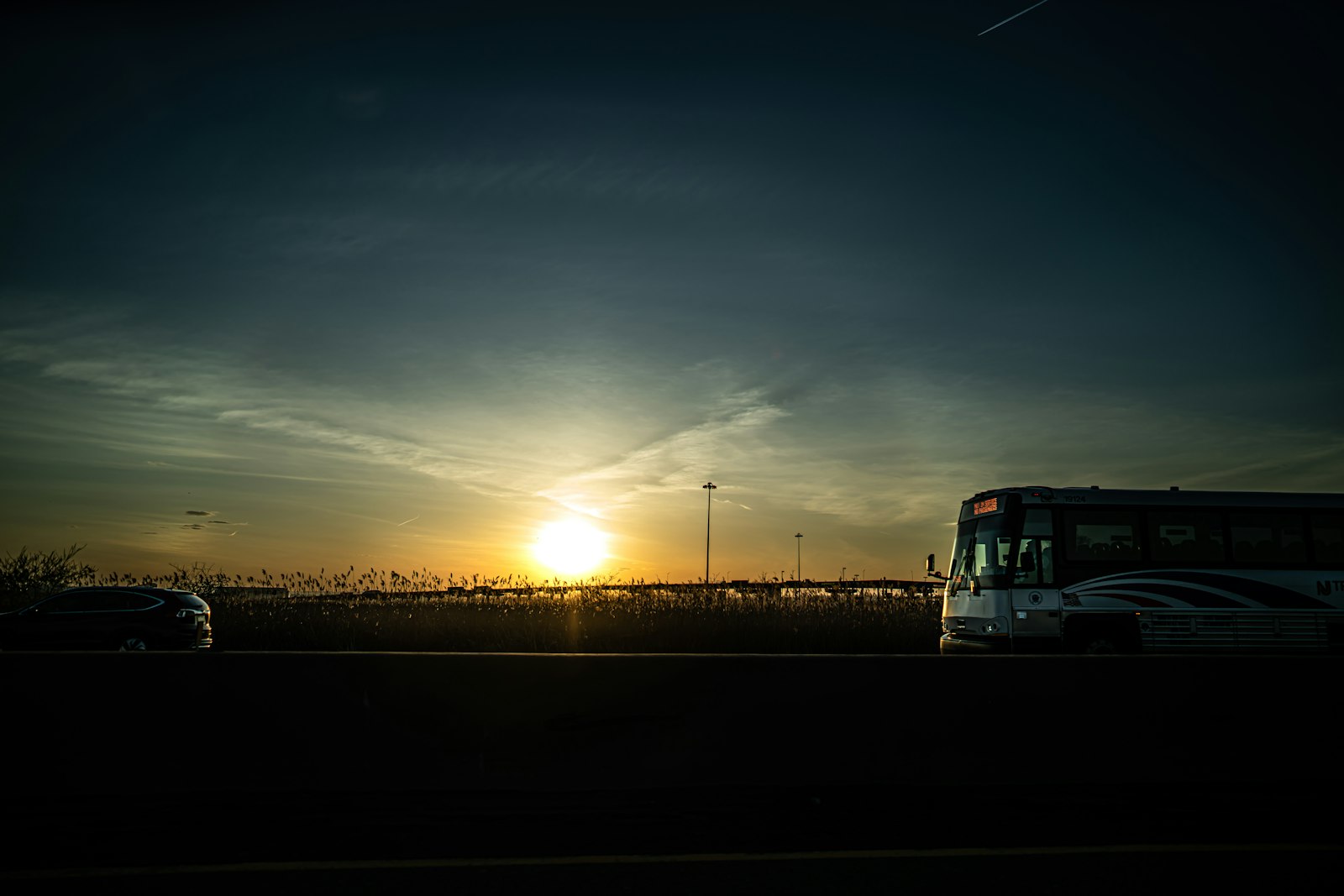 Silhouette of a bus at sunset, the kind of long route where bus and train drivers dental health habits are tested