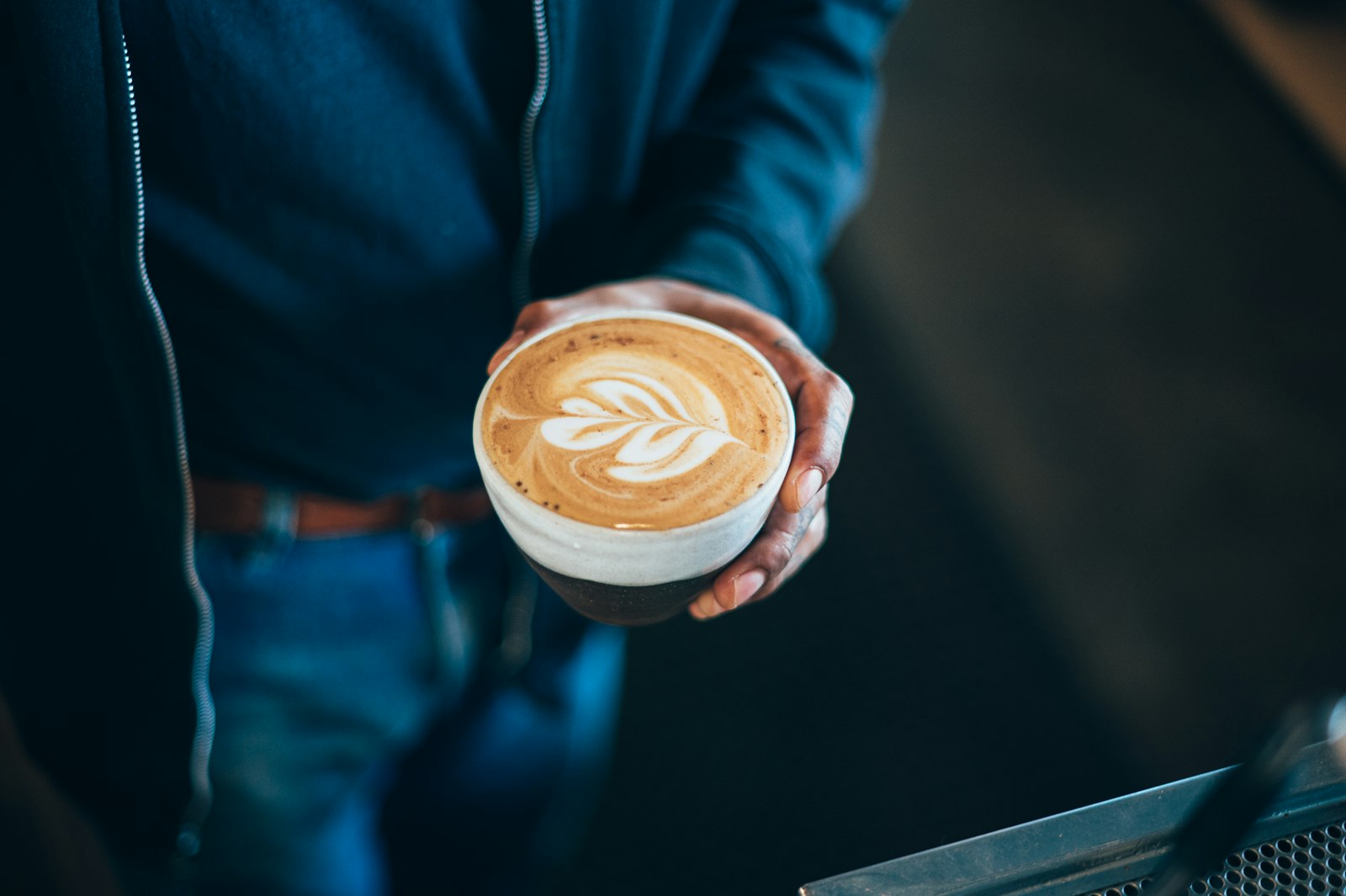Barista serving a latte, illustrating everyday oral health habits in dental health at work by occupation