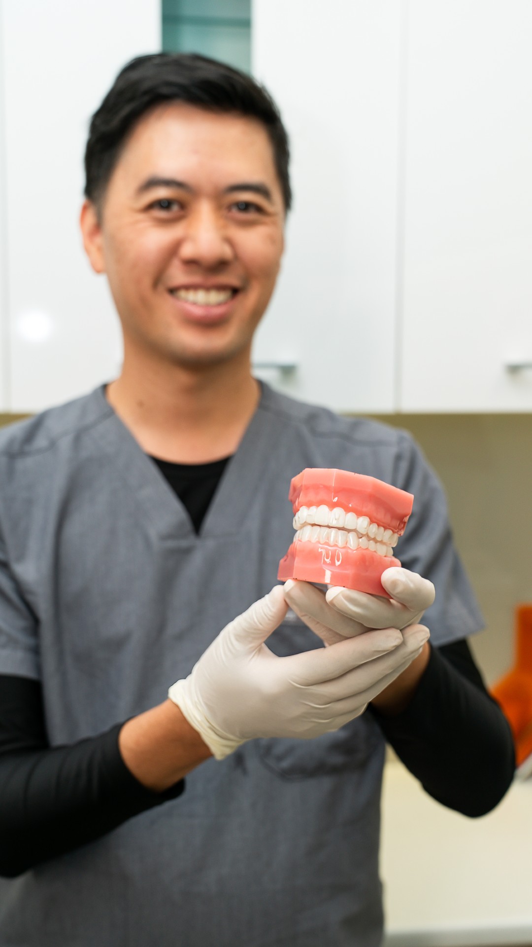 Dr James Tran holding a model of teeth