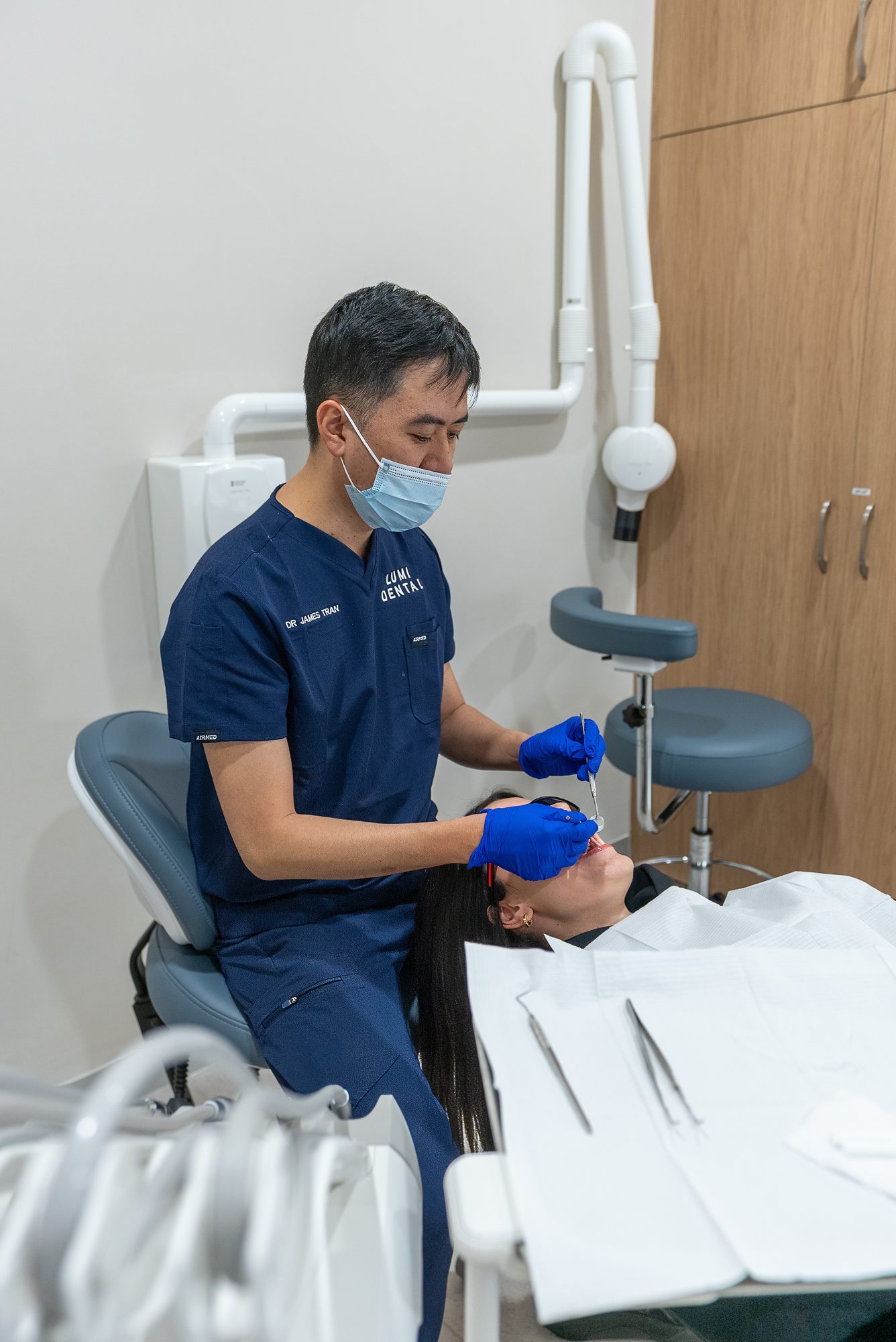 Dr James Tran carrying out a dental examination with loupes and a headlight, part of assessing a failed root canal before a dental implant
