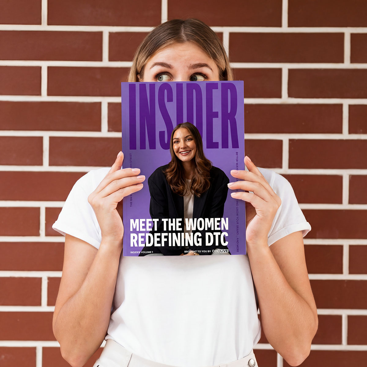 An image of a woman holding DTC Live Insider magazine in front of a brick wall