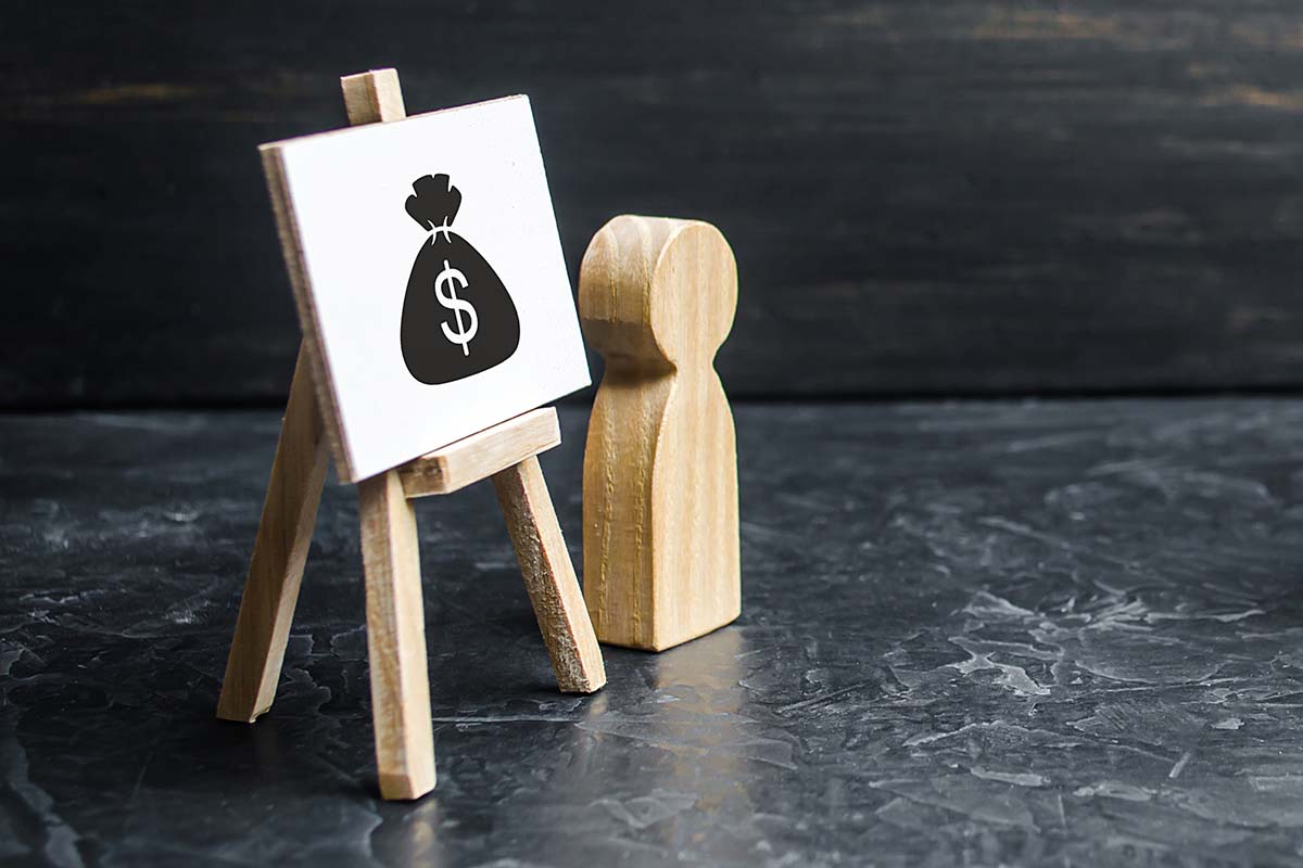 A stock image showing a canvas on a stand with a black money bag painted on it