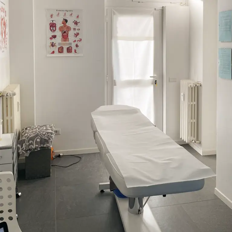 Interno dello studio osteopatico a Varese di Francesca Trivini Bellini, con un lettino medico bianco preparato per i trattamenti.