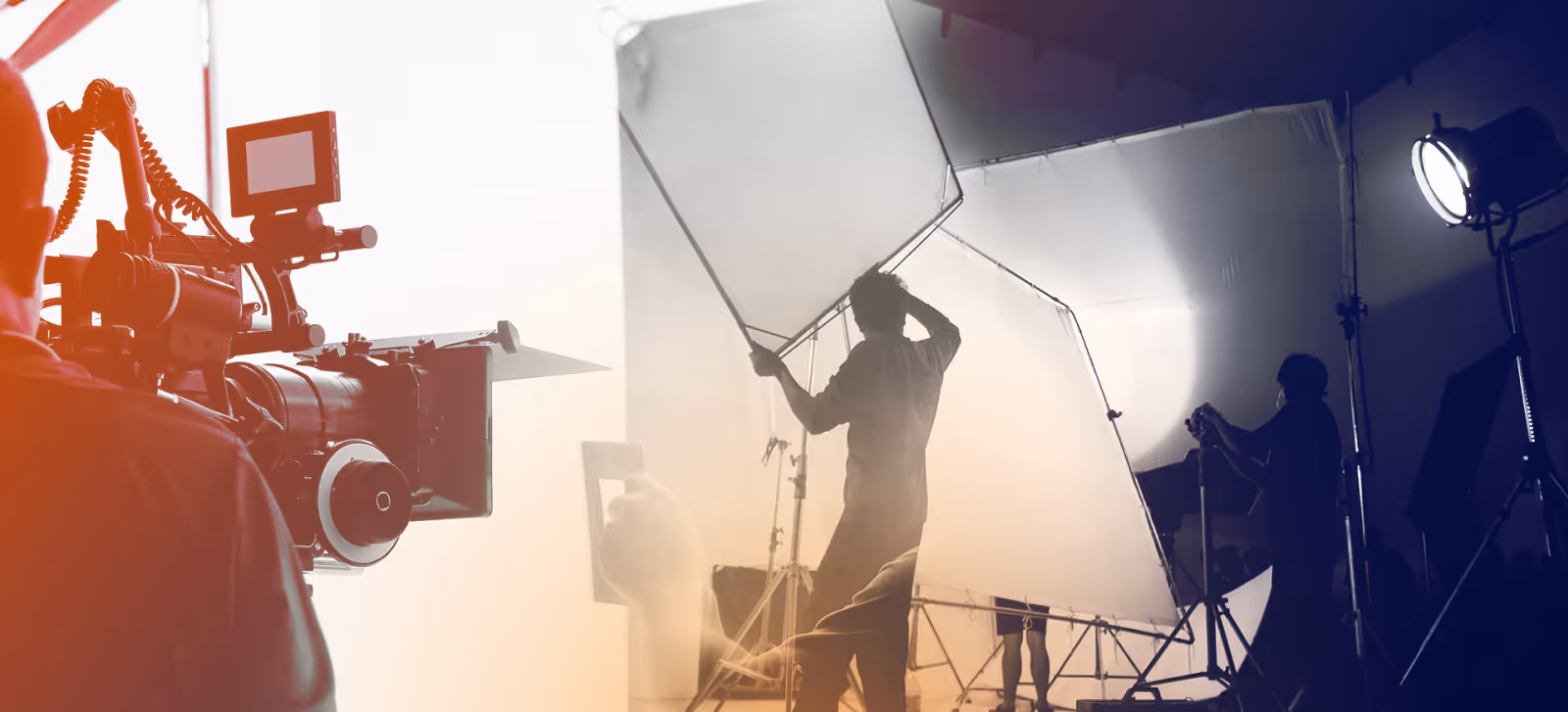 Video production crew adjusts lighting and camera equipment on a professional filming set.