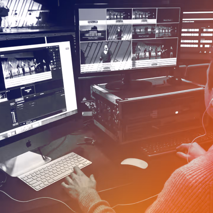 Person working on video editing with dual monitors showing multiple camera views of a live performance.