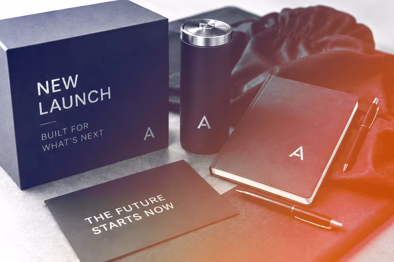 Black box, tumbler, notebook, pens, and card with motivational text on a light surface.