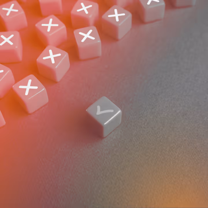 One gray cube showing a checkmark stands apart from many red cubes with white X marks on a gray surface.
