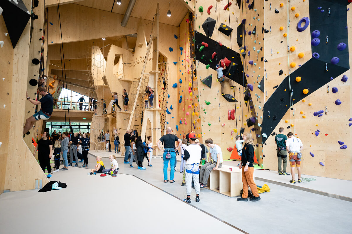 Klatresenteret Høyt Under Taket Skien med høye lyse klatrevegger på hver side av rommet med gripehåndtak og hindere i mange farger