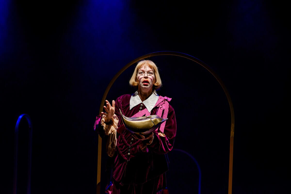 Keiseren i Nattergalen på Amfiscenen, skuespiller Tone Mostraum i keiserdrakt mot en mørk bakgrunn