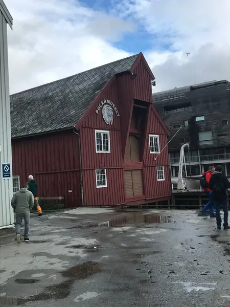 Polarmuseet front mot Tromsø havn, rødt trehus i tre etasjer med spisst tak