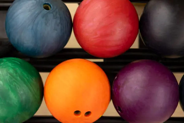 Fargerike bowlingkuler ligger på rad i et stativ klare til bruk som illustrasjonsbilde for aktivitetsprofilen Kilden Bowling & Laser i Tønsberg