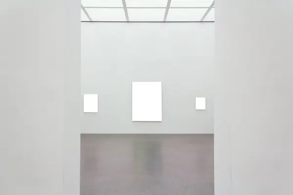 Lysegrå vegger, mørkegrått gulv, glass i taket og hvite firkantede bilder på veggene, illustrasjonsbilde for et kunstmuseum 