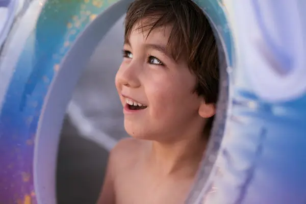 Gutt som kikker gjennom hullet på en svømmering som illustrasjonsbilde for Superland Sarpsborg 