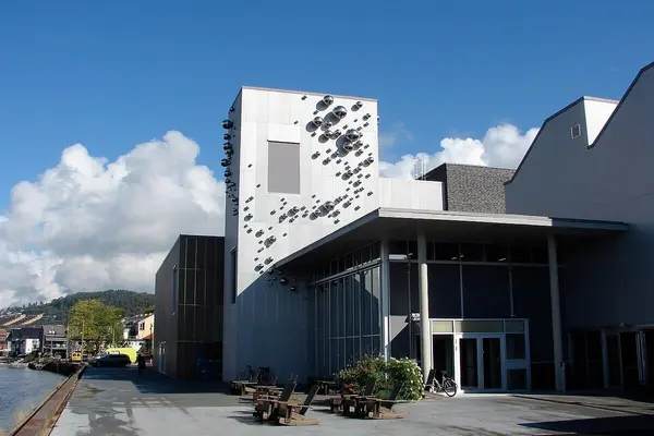 Kulturhuset Ælvespeilet i Porsgrunn, moderne bygning med kunstfasade ved elvebredden på en solrik dag