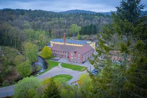 Sjølingstad Uldvarefabrik fotografert fra luften, en stor fabrikksbygning i murstein med skråtak som ligger inntil en like høy stor fabrikksbygning med nesten flatt tak