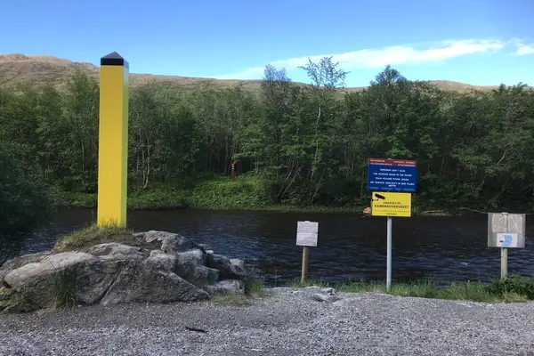 Grenseelv i nord med russisk grensemerke på den ene, og norsk på den andre siden