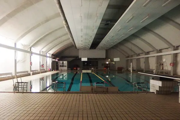 Gjøvik svømmehall, et stor basseng inne i Fjellhallen med hvelvet tak og hvitkalkete fjellvegger på begge sider