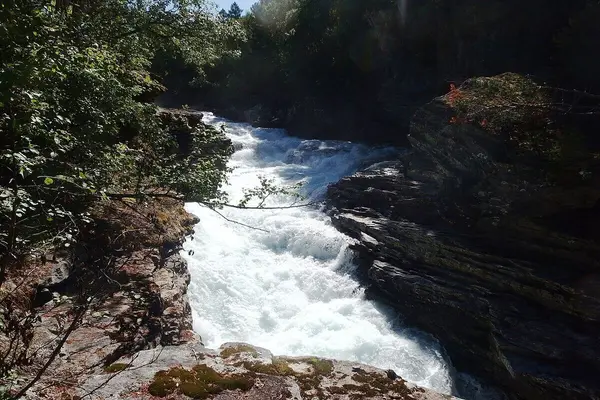 Slettafossen med stor vannføring brusende hvit nedover elveløpet
