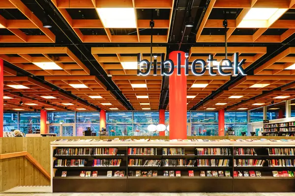 Lesesal med store oransje søyler og brunfarget interiør