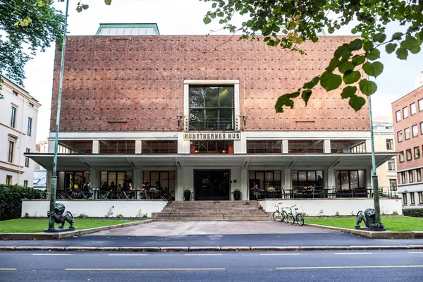 Kunstnernes hus med store bokstaver over inngangen og en høy og bred mursteinsvegg