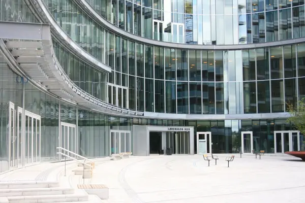 Inngangen til Lørenskog Hus, en buet bygning med glass fra gulv til tak i alle etasjer på fasaden inn mot inngangen 