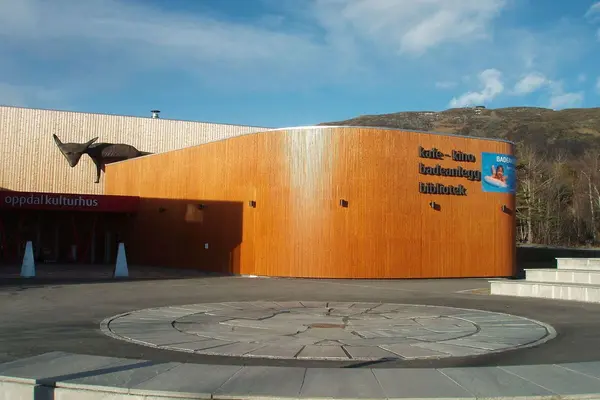 Oppdal kulturhus, inngangspartiet, med kafe - kino, badeanlegg, bibliotek med store bokstaver på et buet utbygg av tre