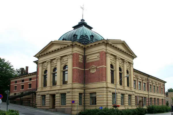 Kulturhuset Banken på Lillehammer, en stor og prangende eldre bygning med  to partier med høye buede vinduer, blanding av rød murstein og gulmalt mur, og et høyt buet kobbertak