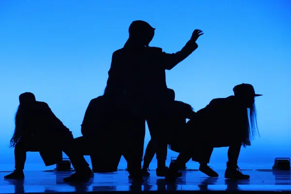 Silhuetter av mennesker på en scene i dunkelt blått lys, som illustrasjonsbilde for beskrivelsen av Blå Grotte i Fredrikstad
