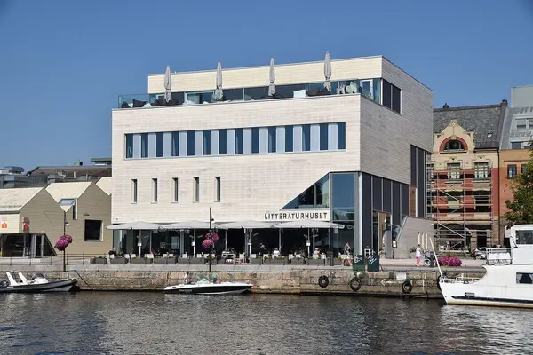 Litteraturhuset Fredrikstad, en stor betongbygning i sjøkanten, sett fra vannet
