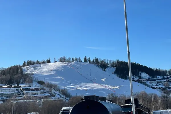 Kirkerudbakken om vinteren sett på avstand en solfylt dag