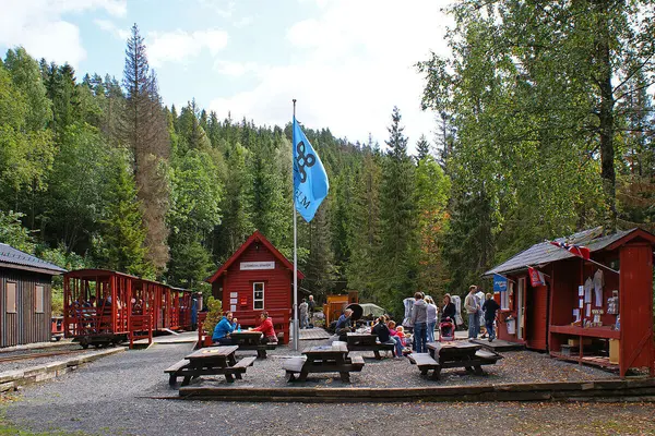 Gundershogget stasjon på Lommedalsbanen med røde stasjonsbygninger og benker og bord