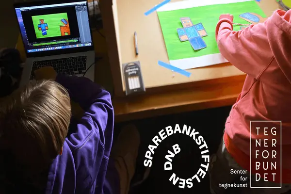 En gruppe barn sitter rundt et bord og tegner sammen med fargerike tusjer og blyanter på et stort ark