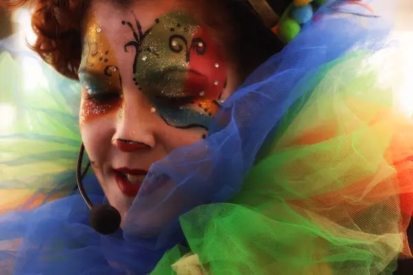 En artist med fargerik ansiktsmaling og kostyme opptrer iført mikrofon, som illustrasjonsbilde for beskrivelsen av familiearrangementer og aktiviteter for barn på Elefantteateret