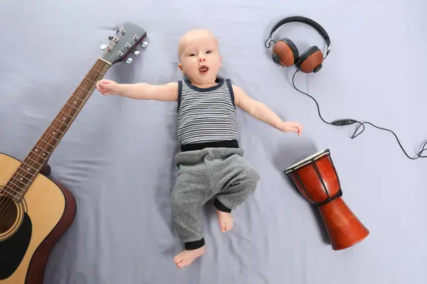 Baby på gulvet blant instrumenter, som illustrasjonsbilde for Musikkmylder – aktivitet for barn 1–4 år på Lørenskog hus.
