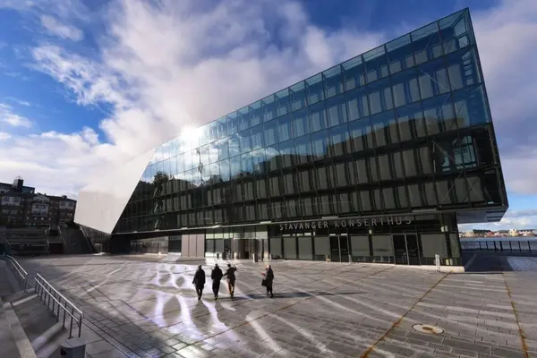 Stavanger konserthus, en stor bygning med fasadevegg som skrår innover og en stor åpen plass foran