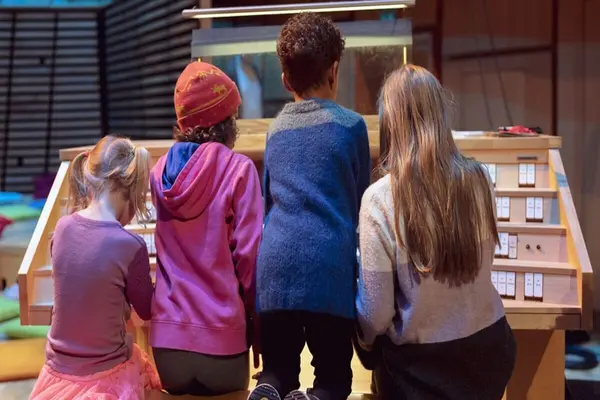 Fire barn står med ryggen til og utforsker et orgel, som illustrasjonsbilde for beskrivelsen av barneforestillinger for hele familien i Stavanger konserthus