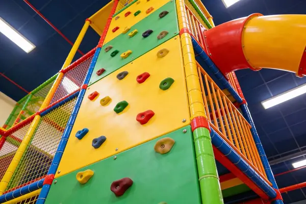 Innendørs lekeland med klatrevegg, fargerike lekeapparater og sklier tilpasset barn, som illustrasjonsbilde for beskrivelsen av Metro Lekeland i Sandefjord