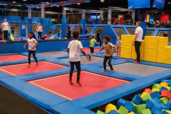 Barn som hopper og leker på trampoliner i en innendørs trampolinepark med skumgrop og aktivitetsområder, som illustrasjonsbilde for beskrivelsen av Rush Trampolinepark Larvik