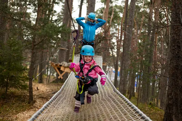 Smilende lite barn med blå hjelm som sammen med en forelder løper over en trampolinestreng, som illustrasjonsbilde for beskrivelsen av Høyt & Lavt Trondheim
